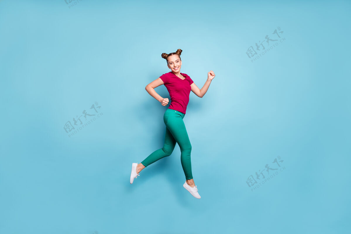 青少年全身尺寸照片欢快正面侧面轮廓穿着红色t恤的女孩微笑着牙齿跑步销售跳起来在裤子绿色隔离粉彩蓝色墙壁飞行快速时尚