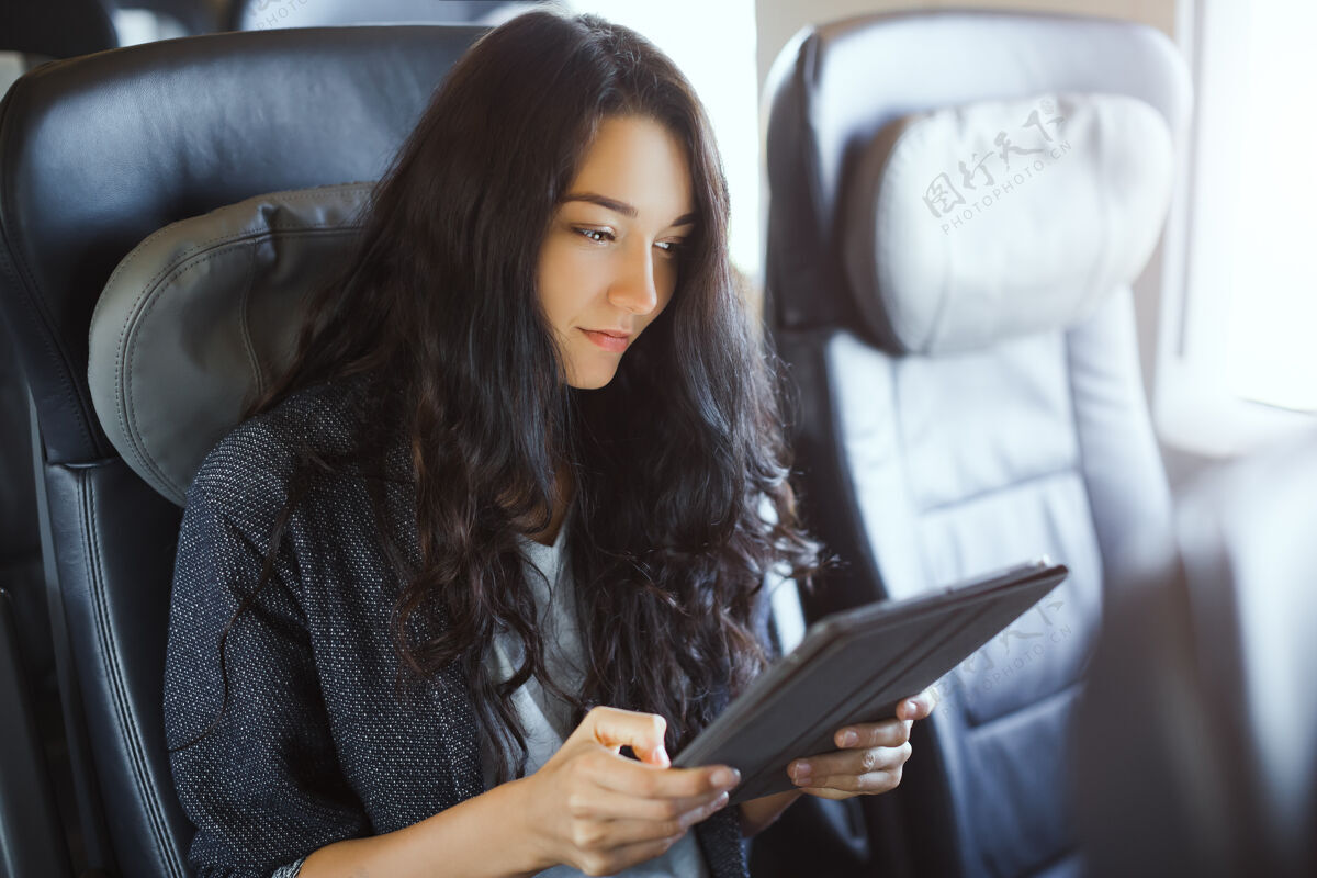 20秒年轻的女游客在旅游时使用她的平板电脑火车旅行应用程序模型西班牙平板电脑