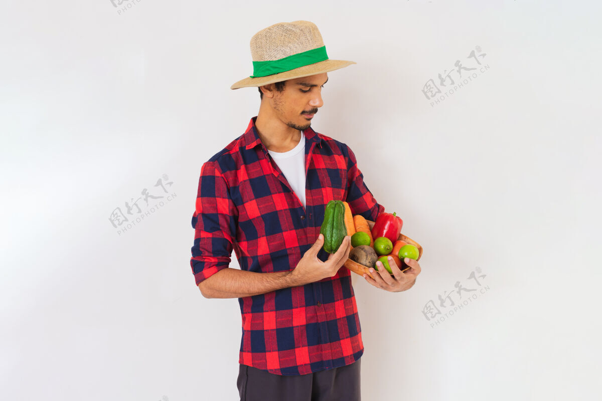 蔬菜一个戴着帽子和手套的黑人农民手里拿着一篮子蔬菜（胡萝卜 柠檬 西红柿 佛手瓜和甜菜） 背景是白色的快乐柠檬欢呼