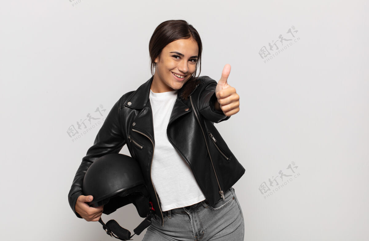无忧无虑年轻的西班牙裔妇女感到自豪 无忧无虑 自信和快乐 积极微笑 竖起大拇指骑手摩托车女孩