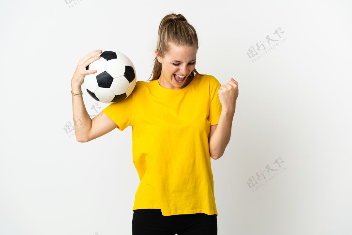 休闲年轻的白种人女子与足球庆祝胜利孤立的白色背景训练女子青年