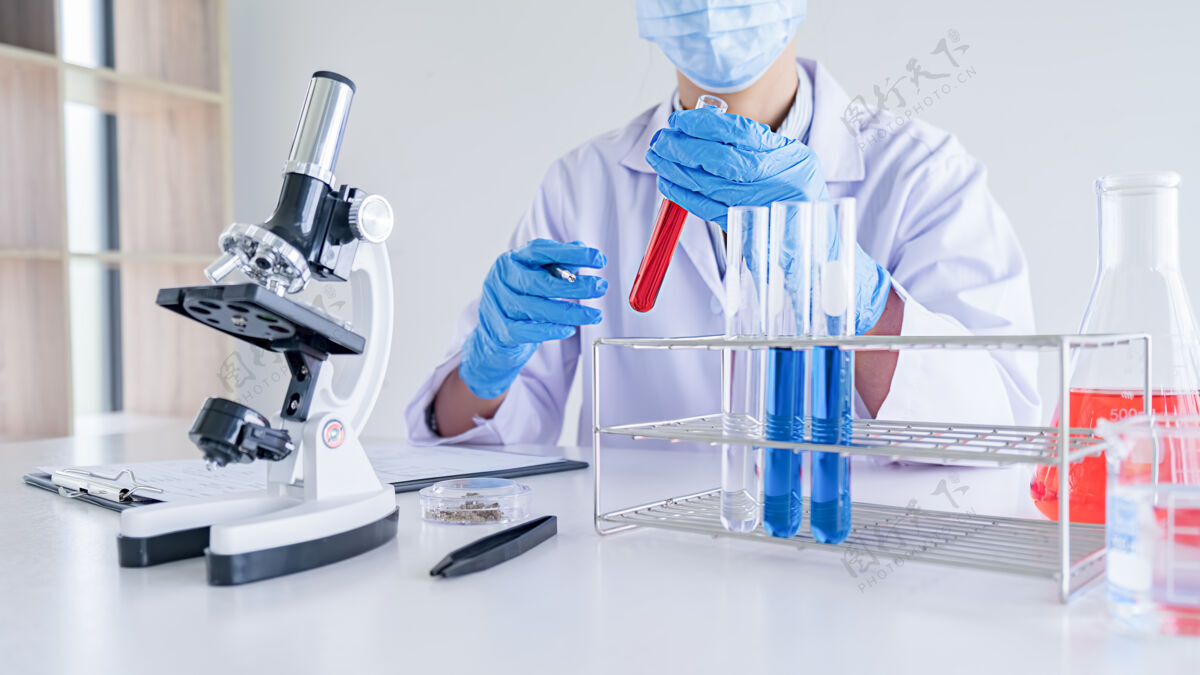 玻璃医学或科学研究人员或男医生在实验室里看着透明溶液的试管化学家生物技术安全