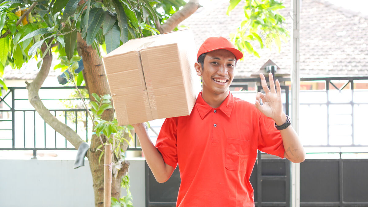 手套送货员把箱子交给顾客 好的房子购物包装
