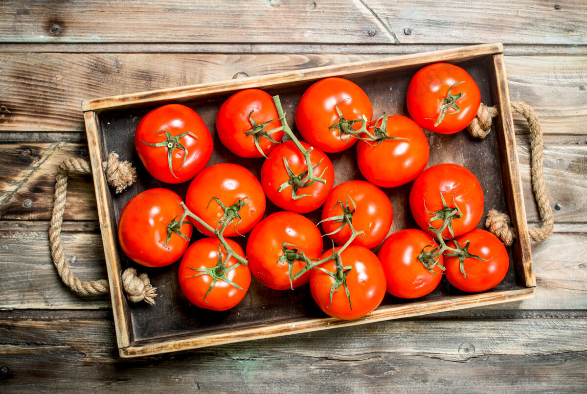 季节红色西红柿托盘.on木制背景光滑番茄生长