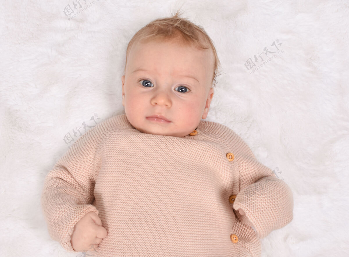 新生儿可爱的小白种人认真的宝贝 看着相机 仰面躺着白种人婴儿三个月婴儿