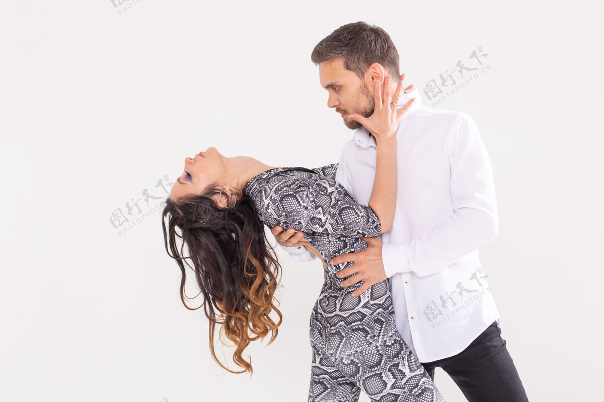 莎莎舞社交舞蹈 巴查塔 基佐姆巴 祖克 探戈概念-男子拥抱女子 而在白色的舞蹈男人女人舞蹈