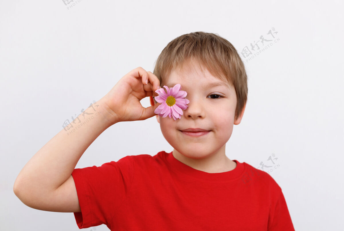 开花一个可爱男孩的画像 眼睛上戴着一朵花植物喜悦洋甘菊