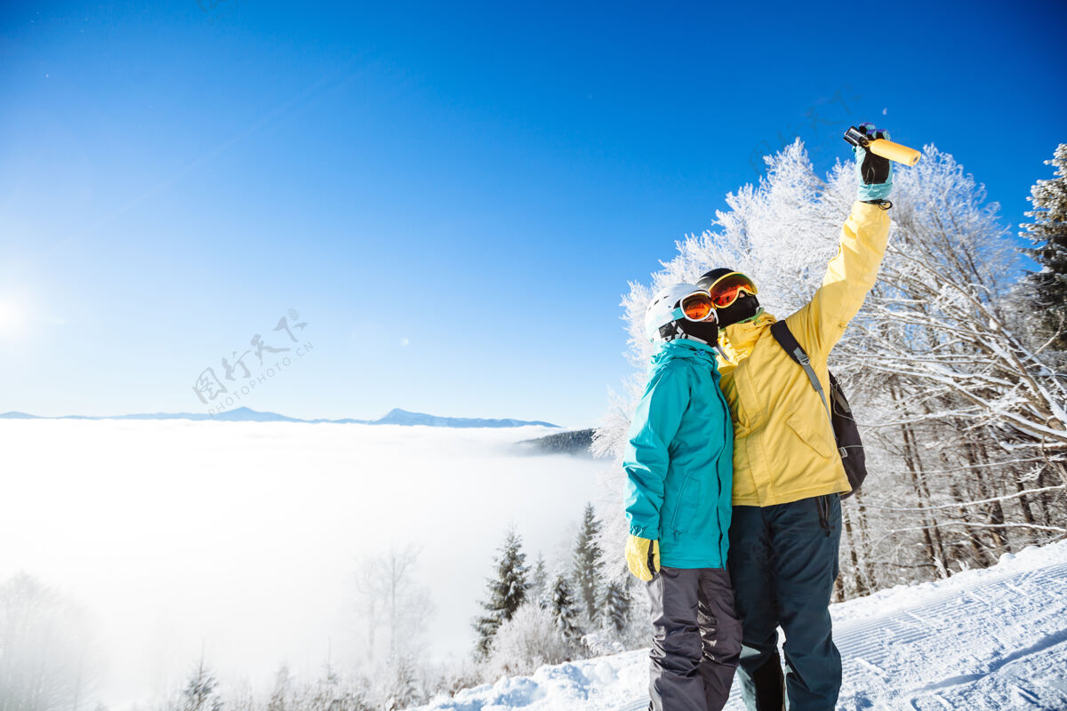 享受滑雪者在山上用智能手机拍照假期度假村装备