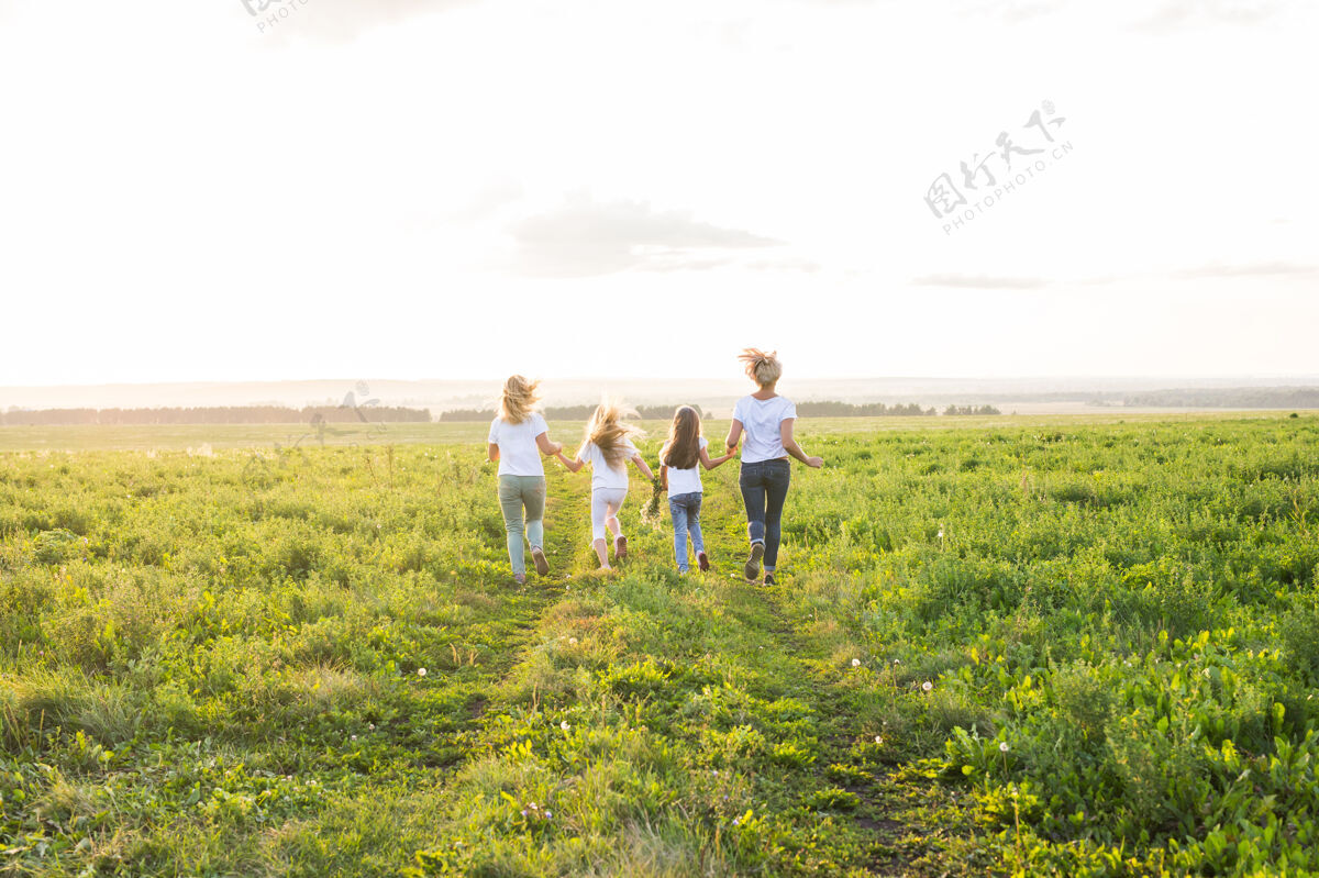 领域家庭 夏日和假日的概念-一群女人和女孩在绿野中离去自由植物家庭