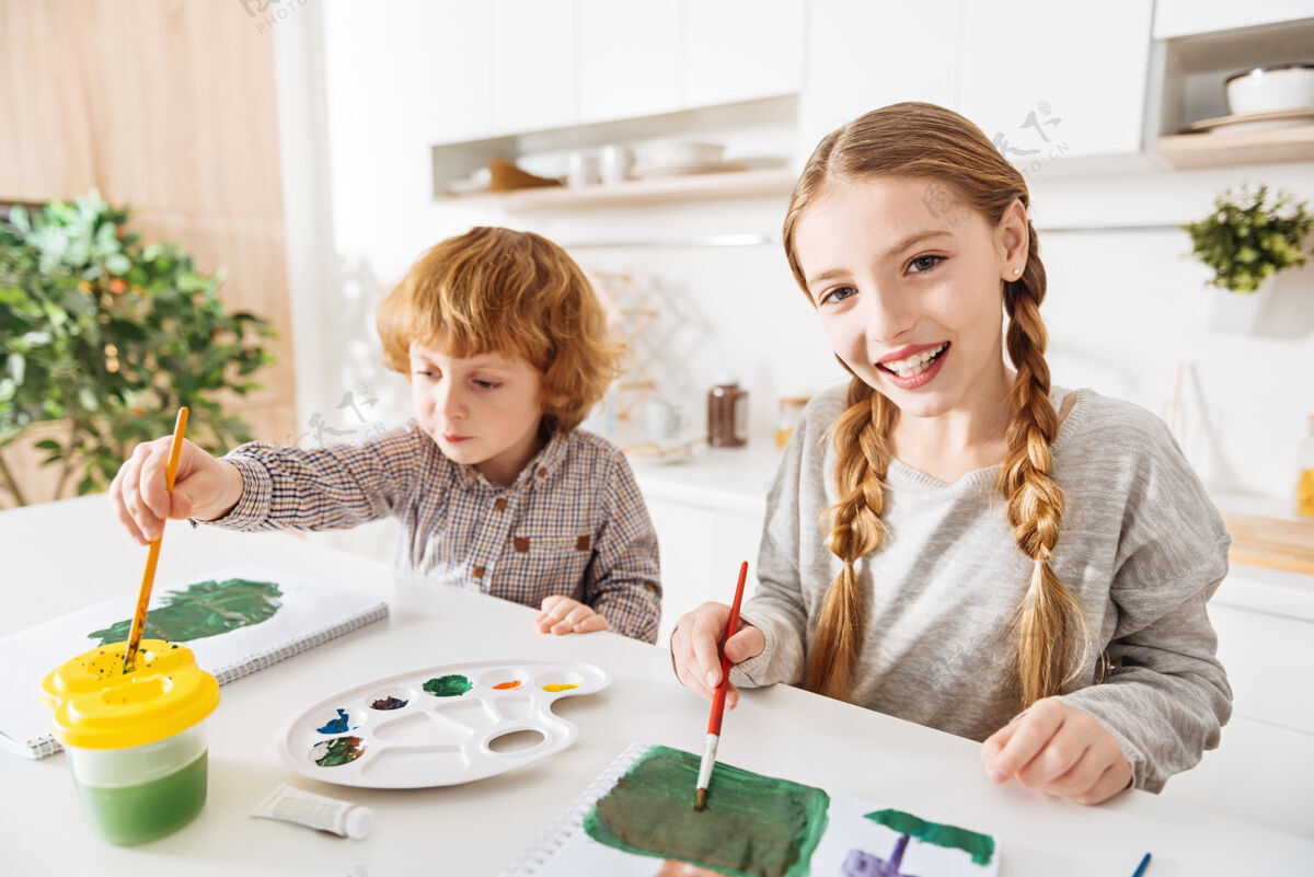 周末创建调色板激情快乐美丽的女孩在画画时用了很多绿色的色调 在家里和弟弟一起尝试新买的颜色人才上午激情