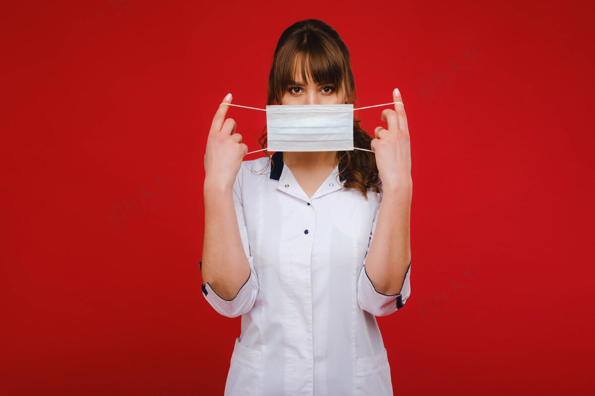 冠状病毒一位女医生站在隔离在红色背景上的医用面罩里护士站立女孩