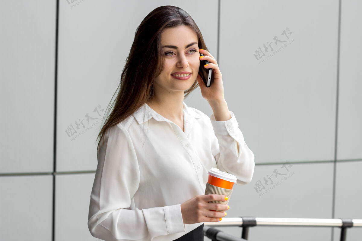首席执行官穿白衬衫的办公室小姐微笑着在电话里说专业工作可爱