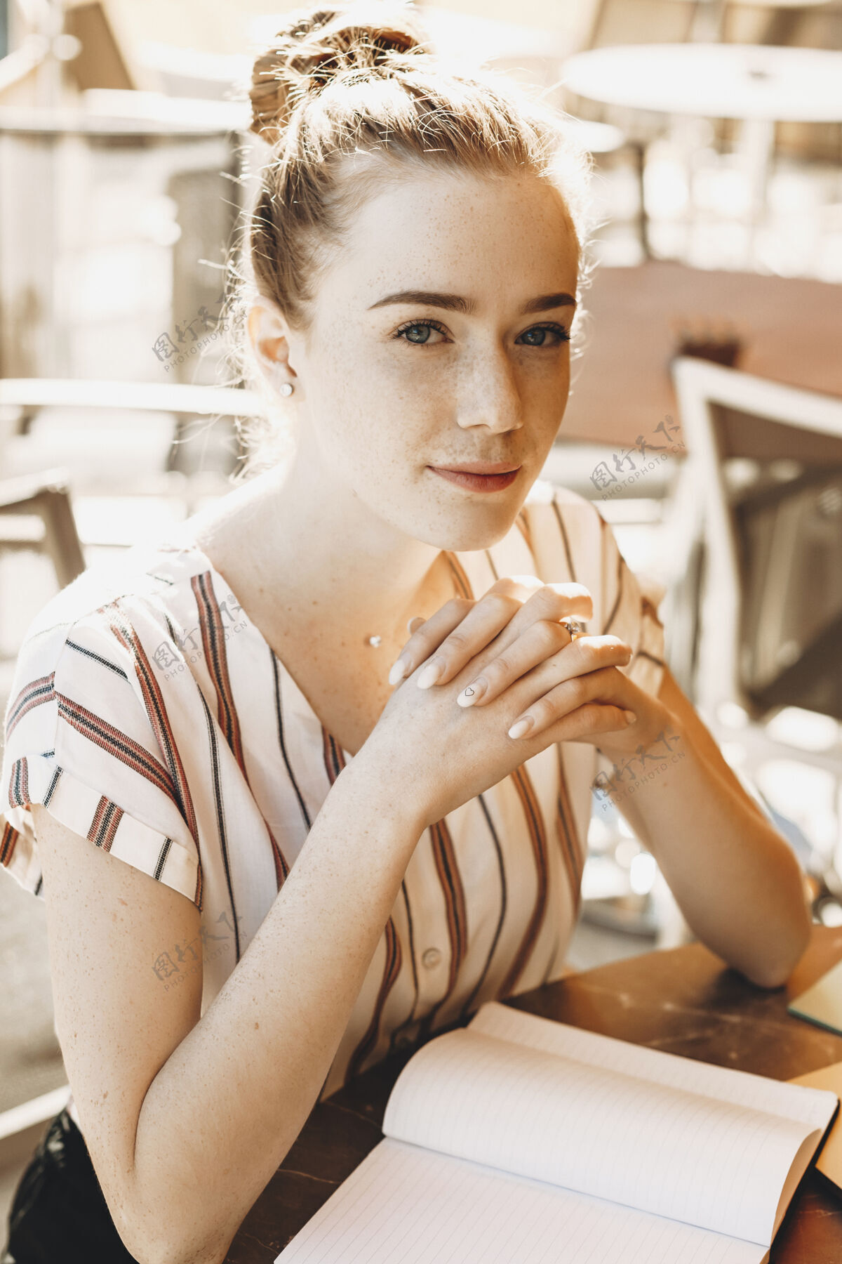 环一位红发雀斑的迷人年轻女子看着相机的肖像微笑年轻可爱的女作家在外面写书咖啡馆红发在线