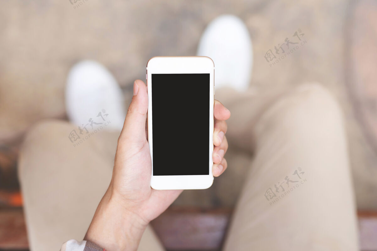电话年轻人穿格子衬衫在休息时用手机拍近身手沙发坐着在休息时间看手机短信放松技术金融无线