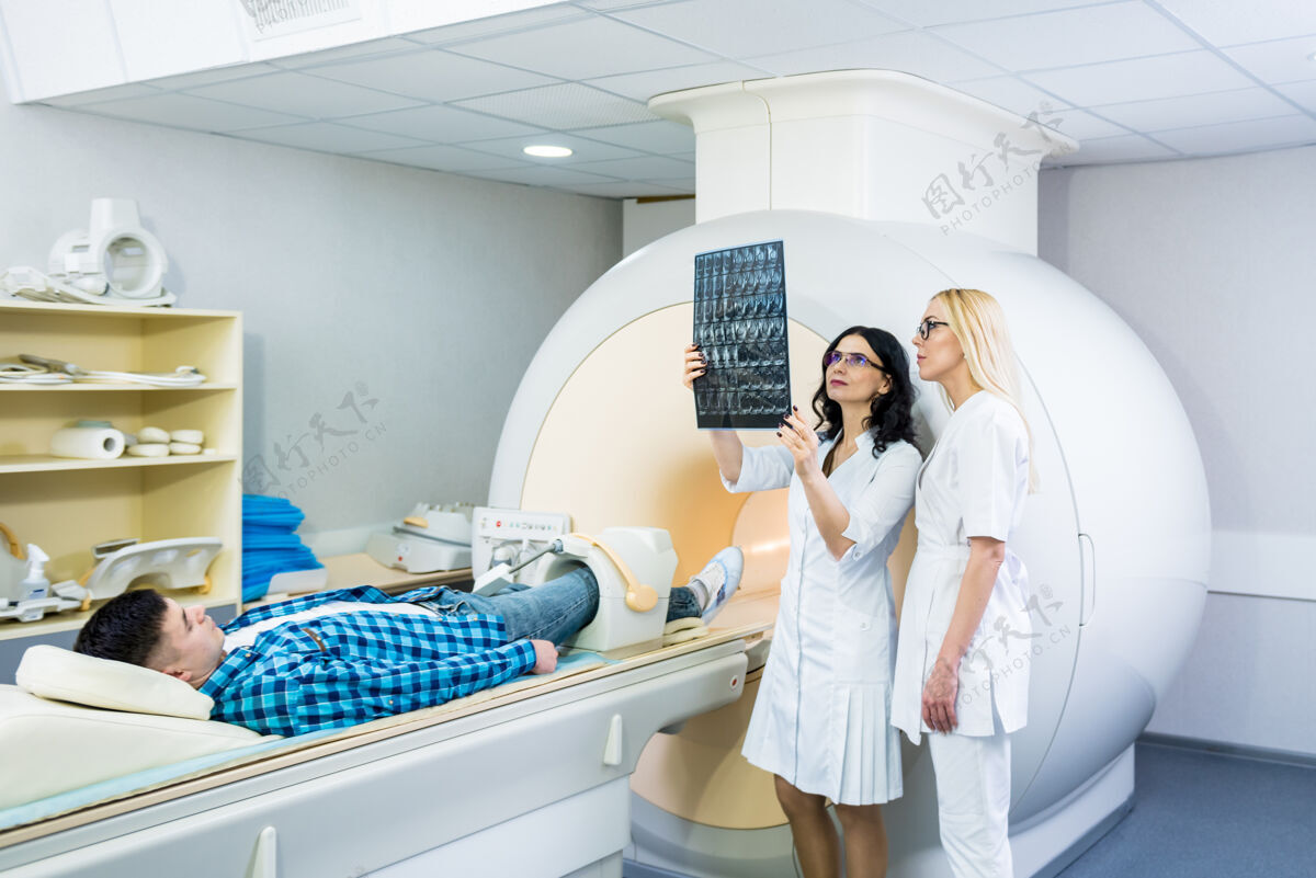 设备放射科医生和一个男性病人一起检查核磁共振扫描医院诊断技师