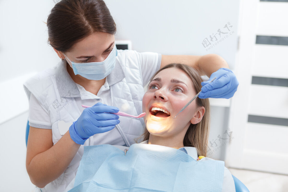 牙科年轻的女人正在牙医那里检查她的牙齿健康微笑诊所