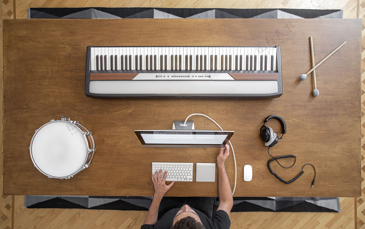 音乐音乐键 棍子 鼓 耳机和一个木制的电脑工作场所表一个音乐家的声音工作工作场所电脑钢琴
