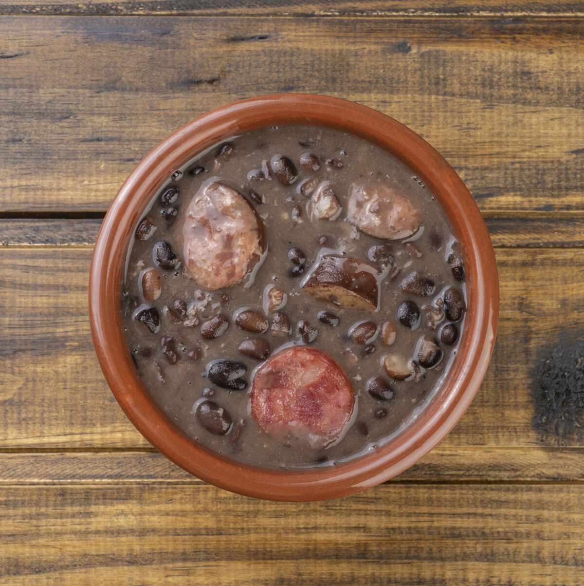 肉传统的巴西feijoada放在木桌上的碗上培根食物饭