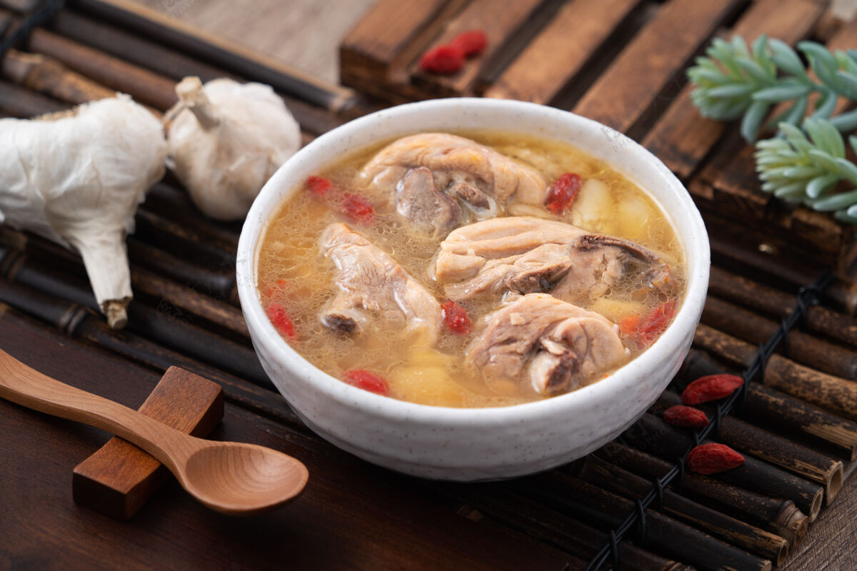 美食台湾菜-自制美味的蒜味鸡汤放在一个碗里 背景是深色的木桌特写自制一餐