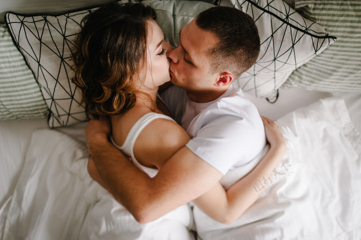 两个一对恋人躺在卧室的床上接吻情人节concept.flat公司躺着查看白色女人事件