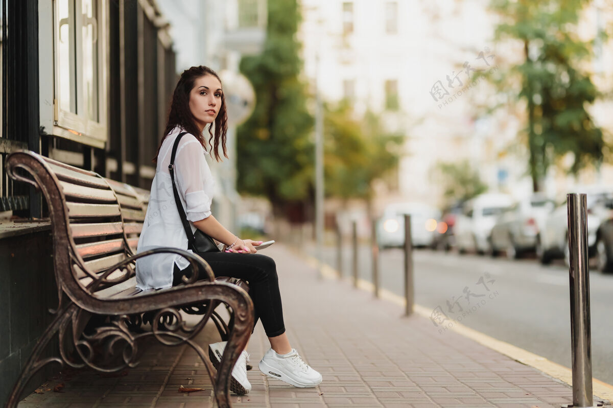 女商人年轻漂亮的女人在车站等公共汽车停高高质量的照片等待车站成人