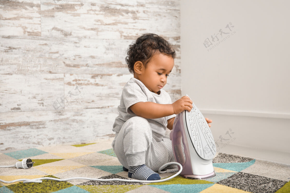 情况一个非洲裔美国小婴儿在家里玩铁家庭.孩子有危险预防措施小心意识