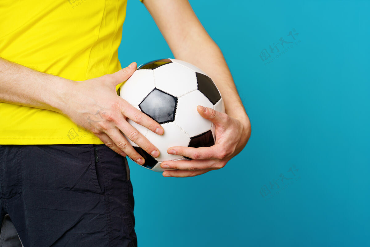 人类男球迷穿黄色t恤 蓝色背景上有足球比赛职业训练