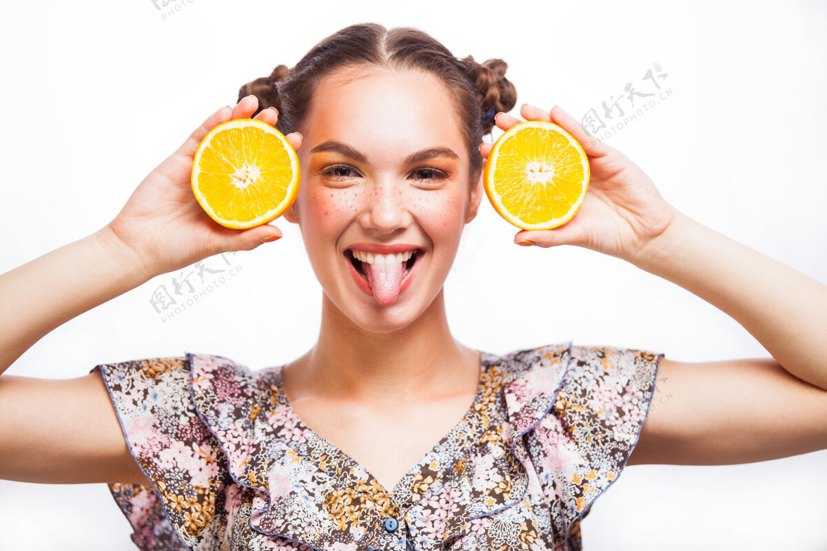 肖像多汁美女模特儿橘子很漂亮快乐的少女 有雀斑 有趣的红色发型和黄色妆容专业制作向上橙色切片隔离在白色背景上成人看时尚