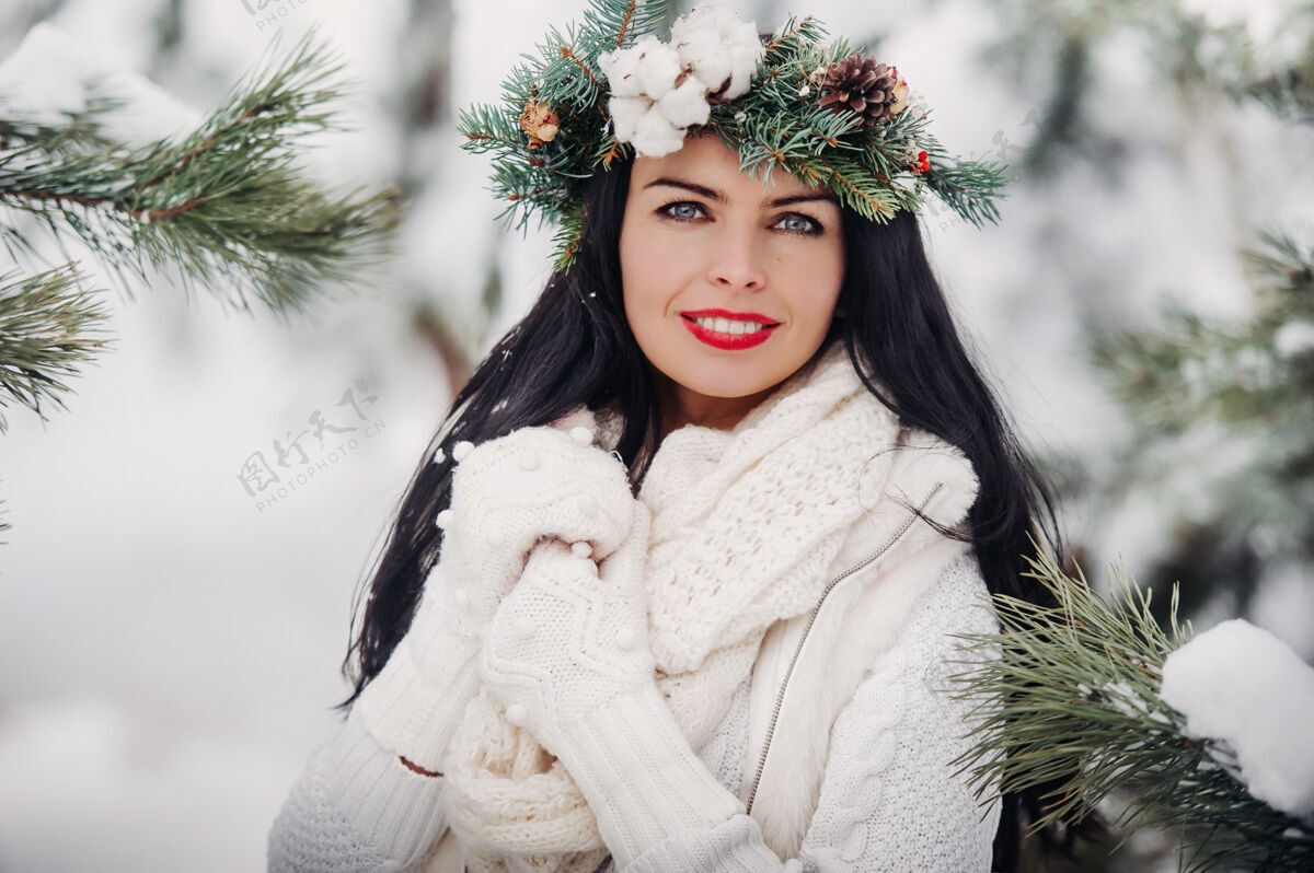 圣诞寒冬白衣女子画像森林女孩她头上戴着花圈在冰雪覆盖的冬季森林里人户外微笑