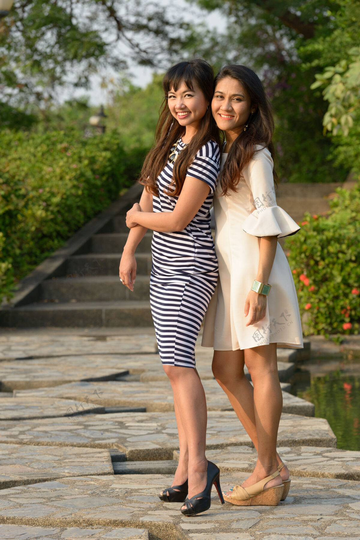 拍摄两位亚洲年轻女性在公园户外放松的写真泰国情侣和平