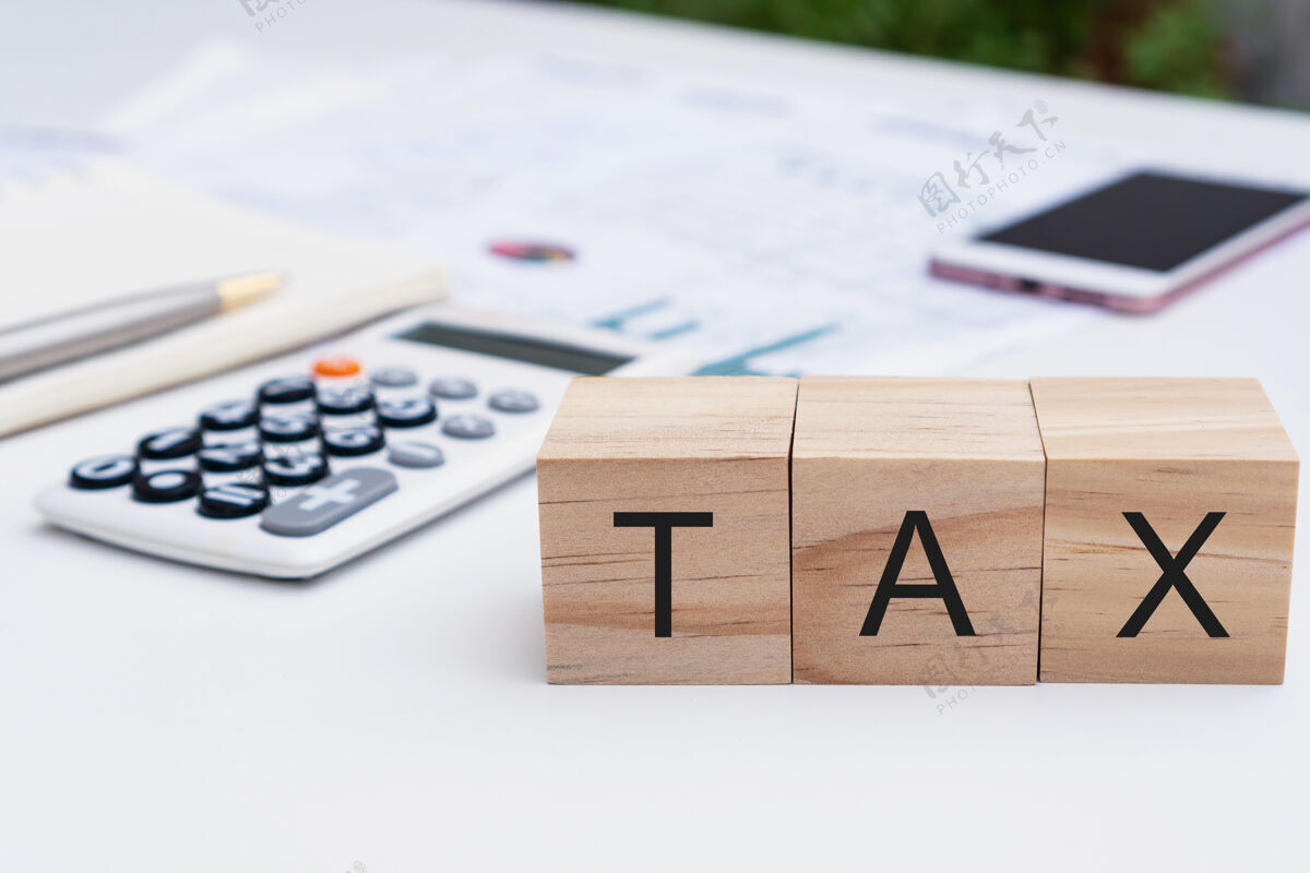 发票木制立方体上的税信特写 笔记本 计算器 白色书桌上的账单付款收据财务