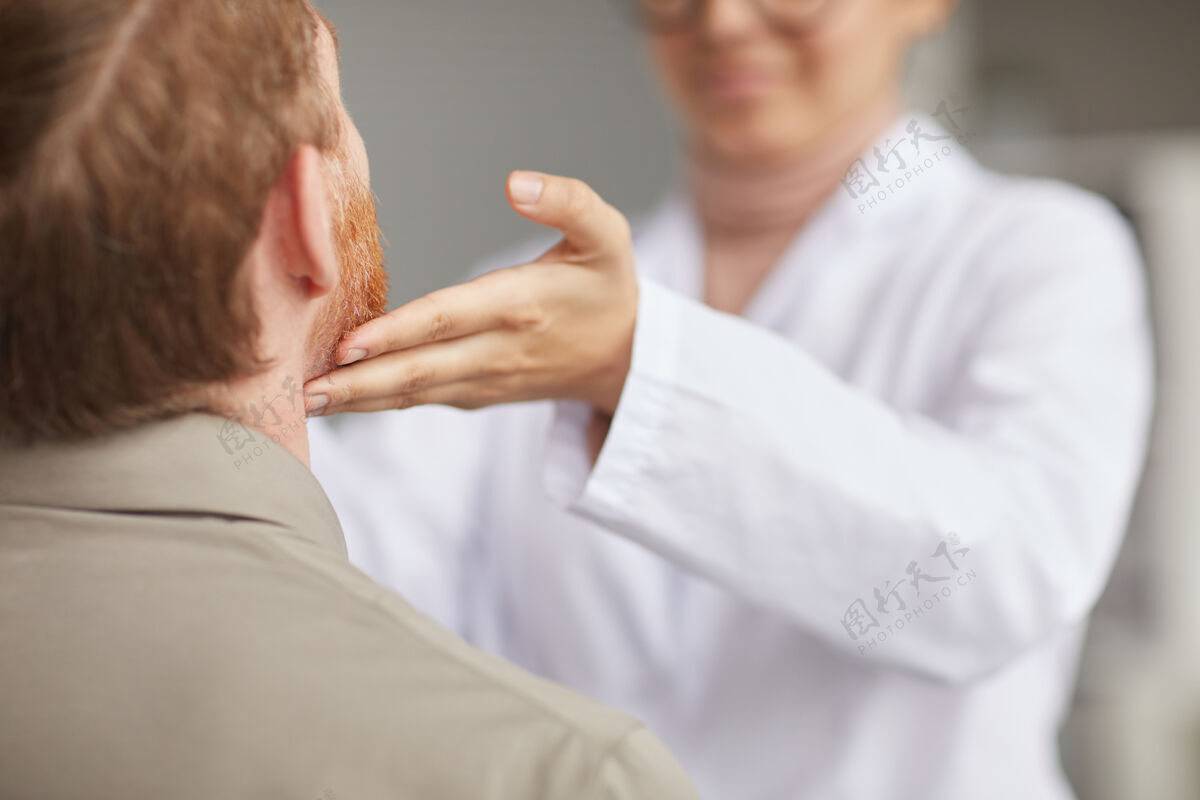 医生办公室医生检查喉部时 男性患者坐在医院就诊的后视图医药检查全科医生