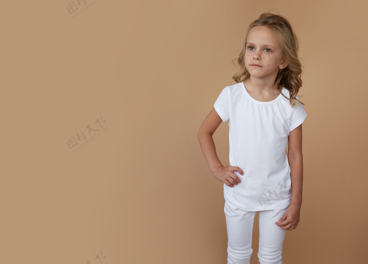 时尚一头卷发 穿着白色衣服的漂亮小女孩的正面肖像金发童年女孩