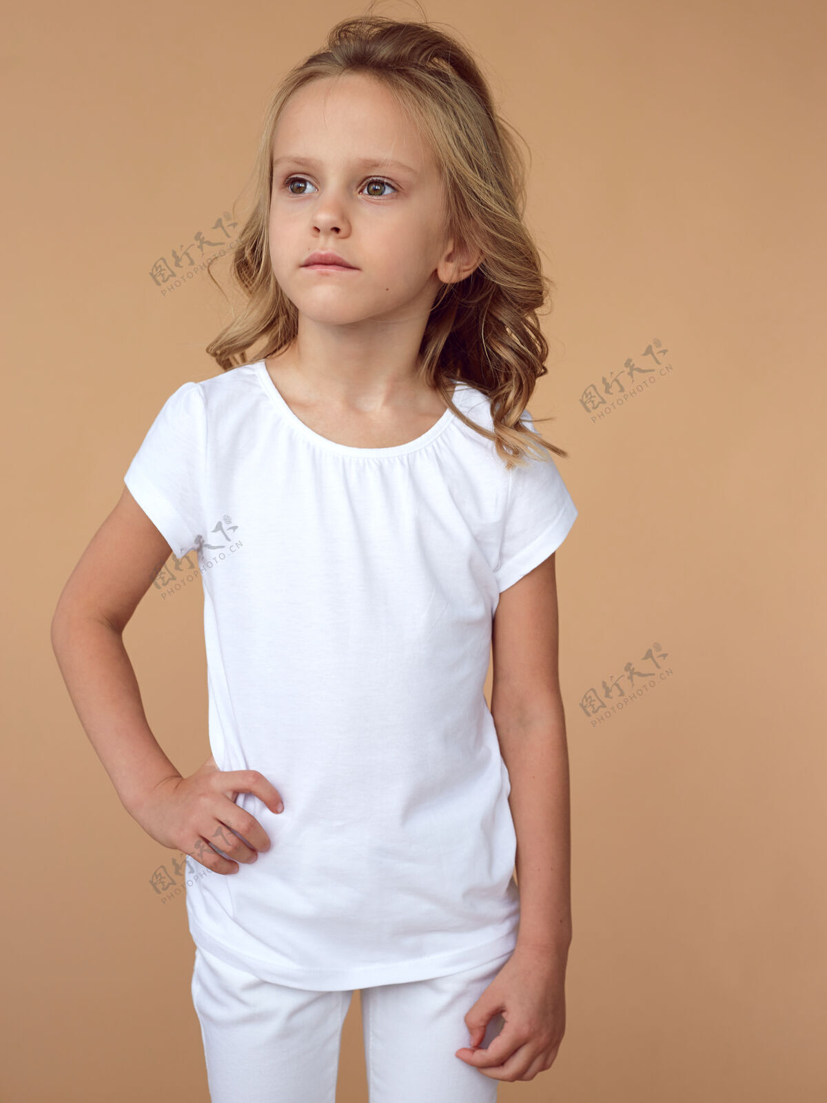 金发一头卷发 穿着白色衣服的漂亮小女孩的正面肖像女孩年轻快乐