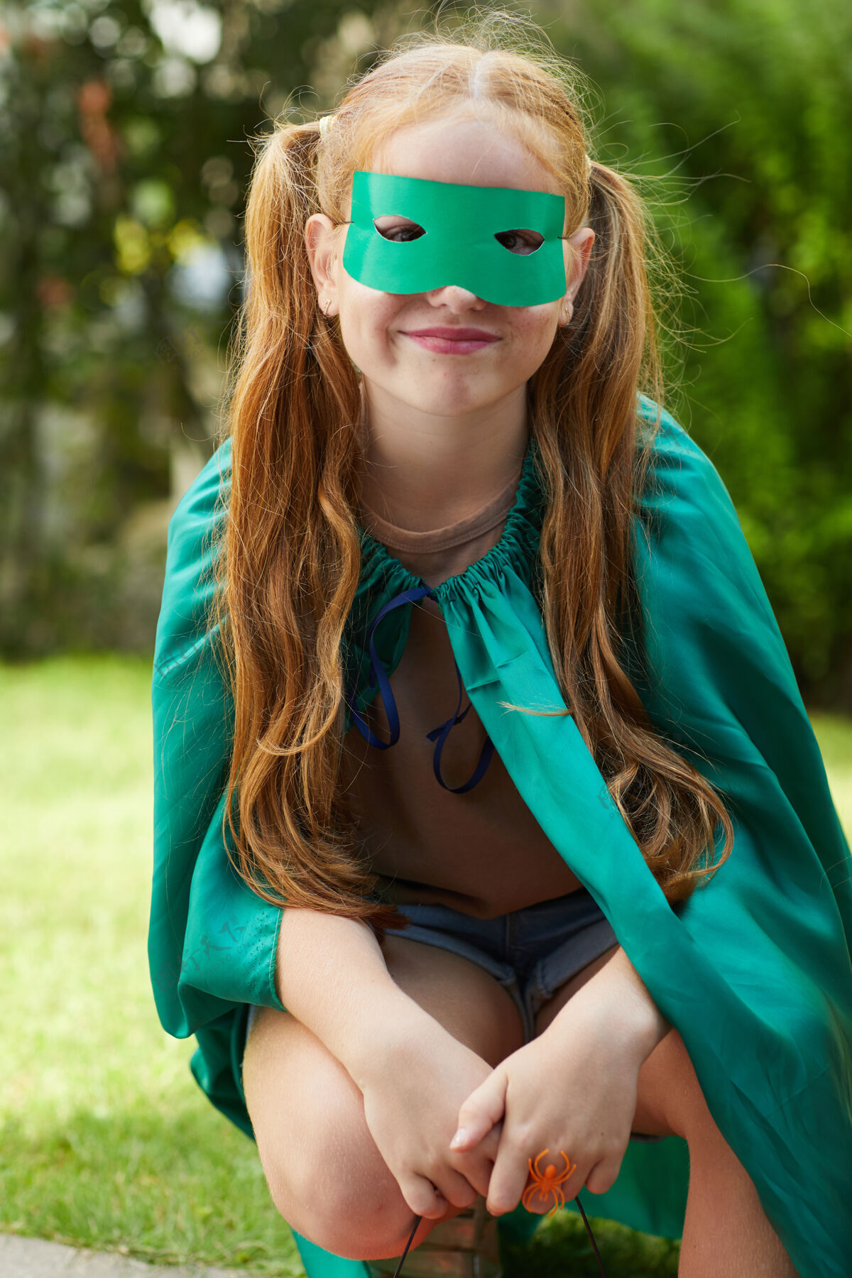 打扮穿着万圣节服装坐在户外的小女孩的画像十月白天绿色