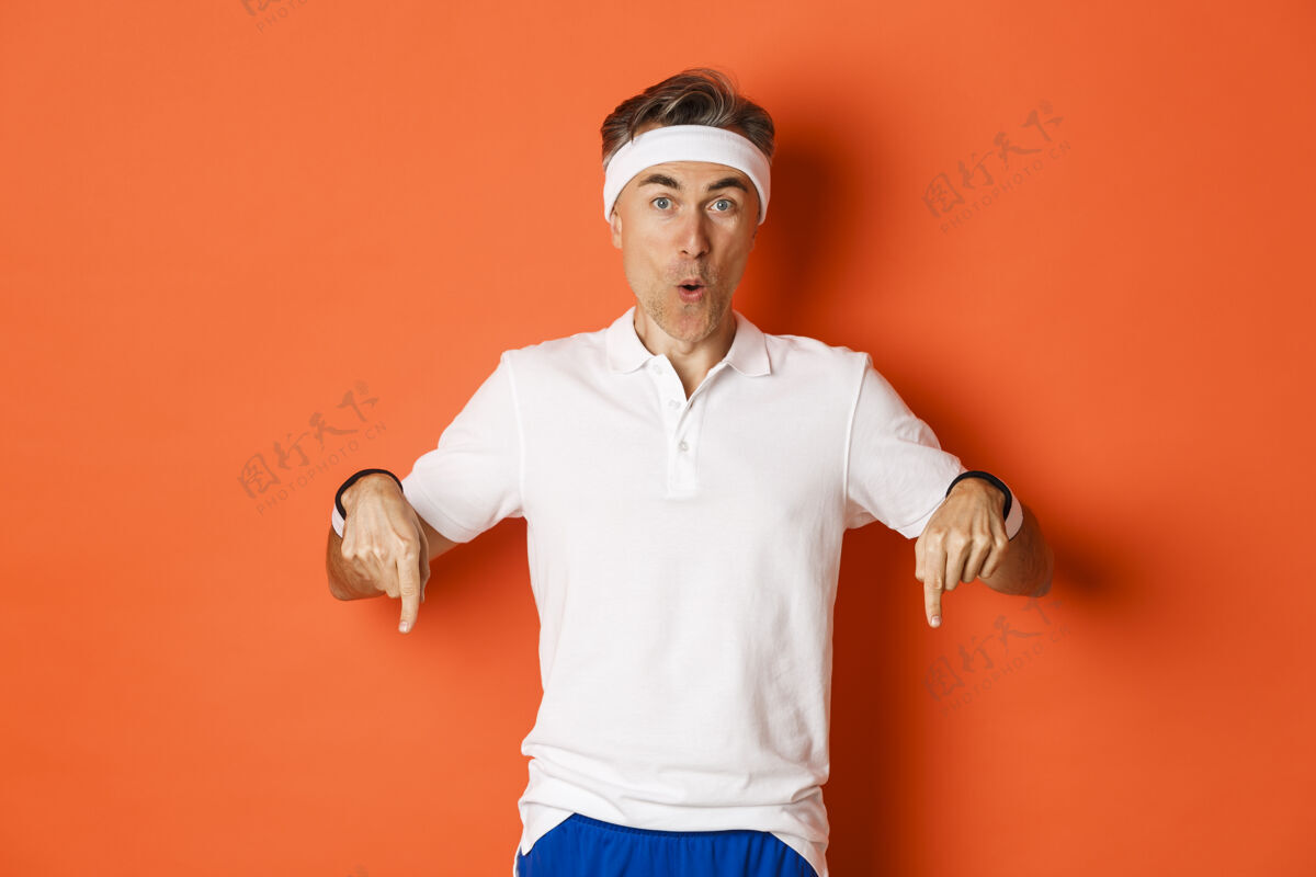 锻炼惊讶的中年男运动员的肖像 穿着健身服训练橙色男性