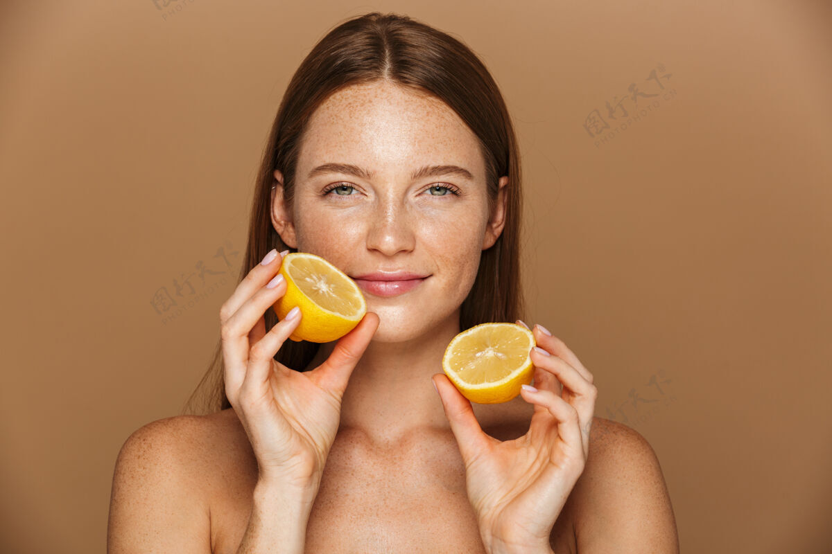 水疗一个性感健康的年轻裸体女人的美丽肖像 长着一头红色的头发 在米色的墙上有一片柠檬欢呼女孩微笑