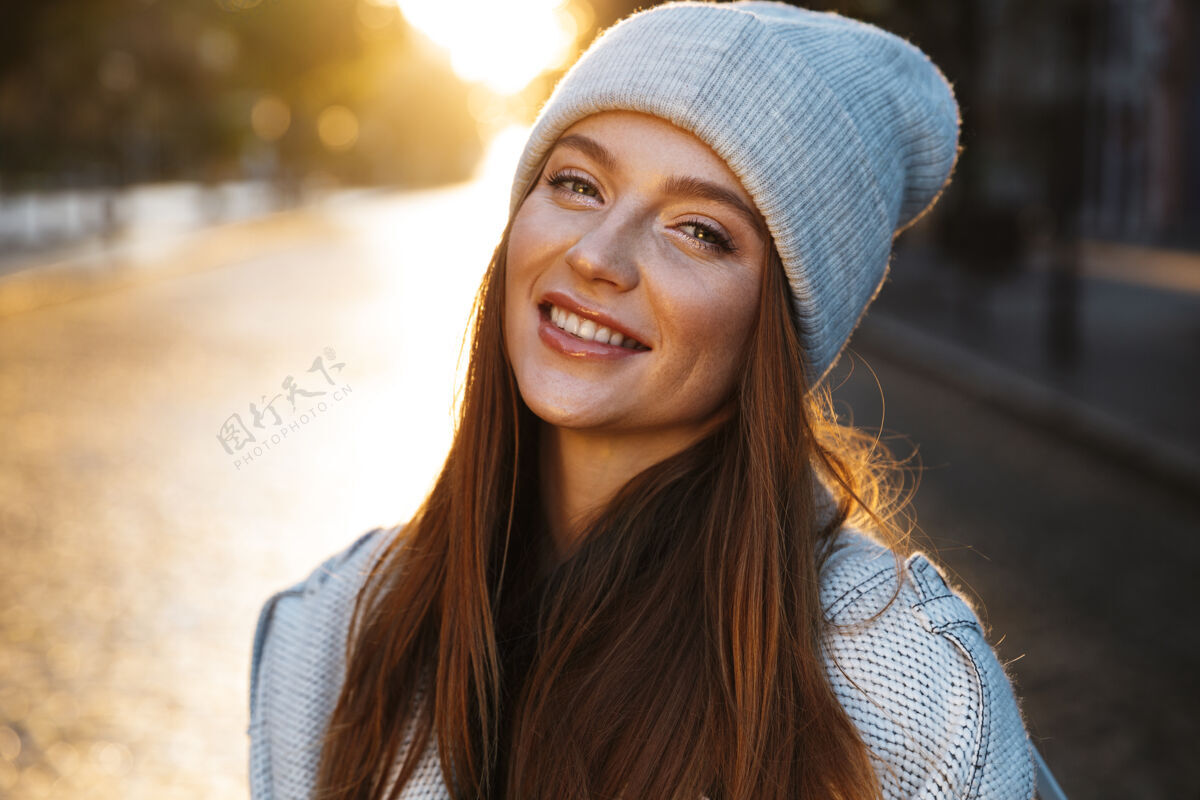 年轻一个穿着秋衣 头戴秋帽 在城市街道上走在户外的快乐的年轻女子城市微笑帽子