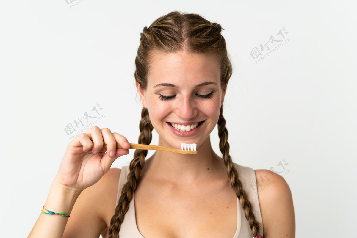 牙科一个年轻的白人妇女用牙刷把自己隔离在白色的地板上刷子墙壁早晨