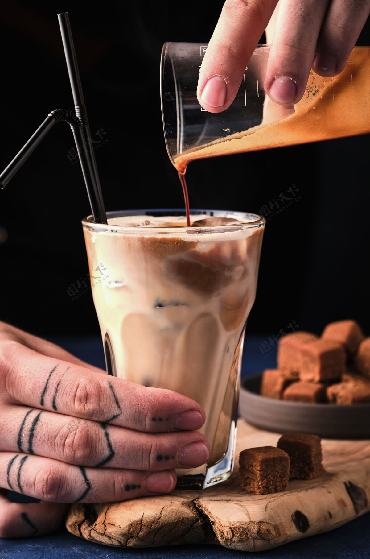 杯子冰咖啡加太妃糖奶油苏格兰威士忌男董事会手把浓咖啡倒进一杯牛奶里太妃糖特写甜点
