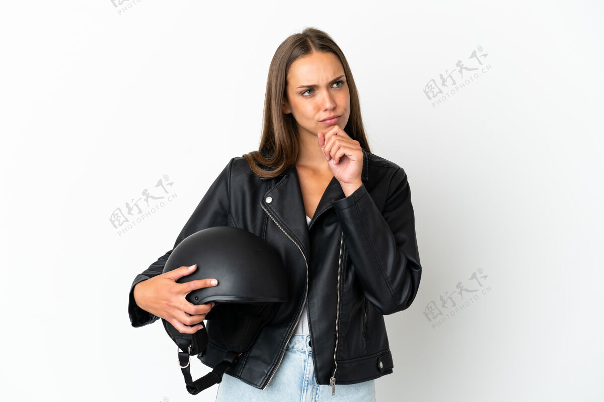 女人一个戴着摩托车头盔的女人站在孤立的白色背景上抬头看空白驾驶自行车