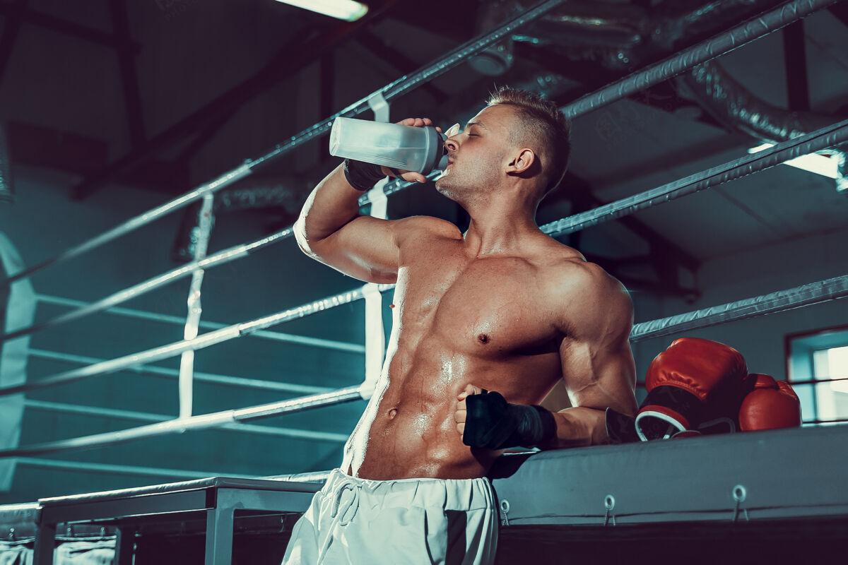喝酒肌肉发达的白种人 在拳击运动后休息 在健身房喝摇床里的水运动补充比赛