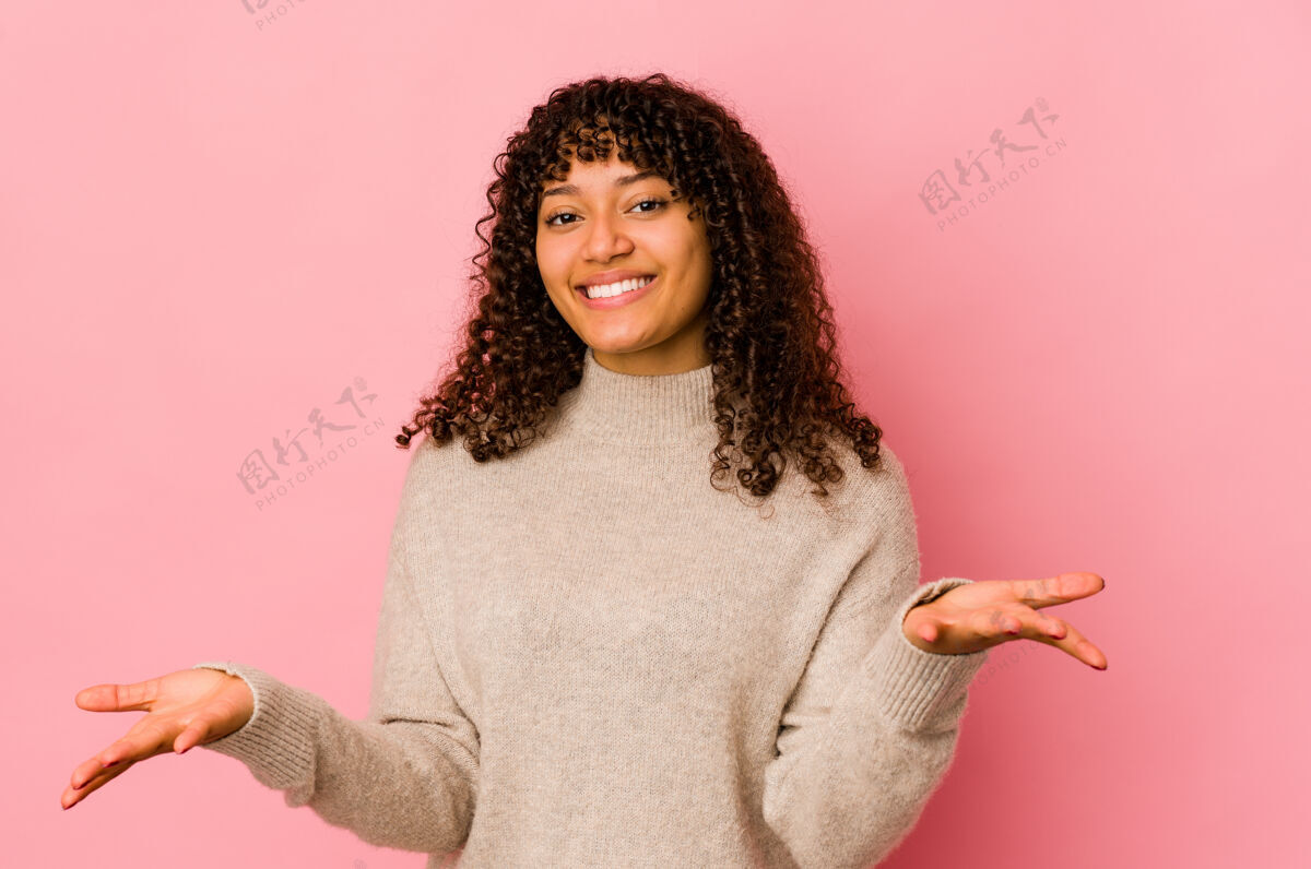 决定年轻的非洲裔美国黑人女性 孤立无援地用手臂做天平 感到快乐和自信女性混血卷发