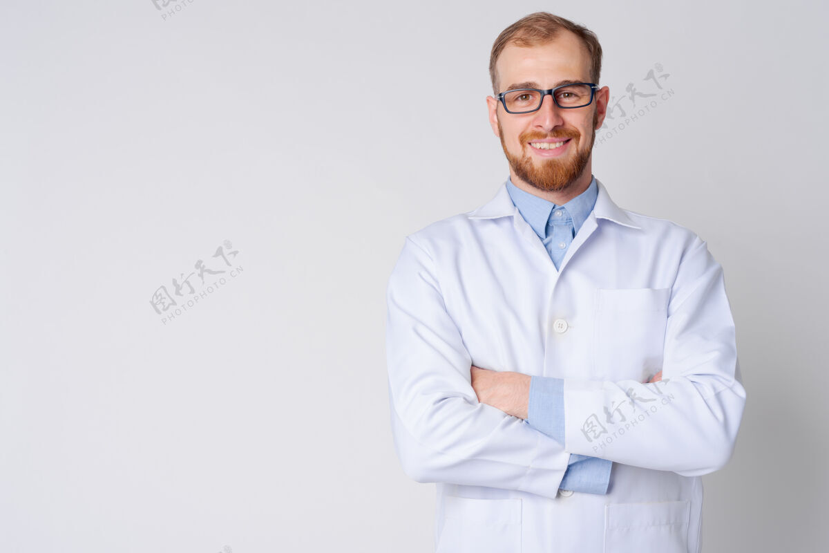 制服快乐的年轻胡须男医生戴眼镜双臂交叉的肖像男人医疗眼镜