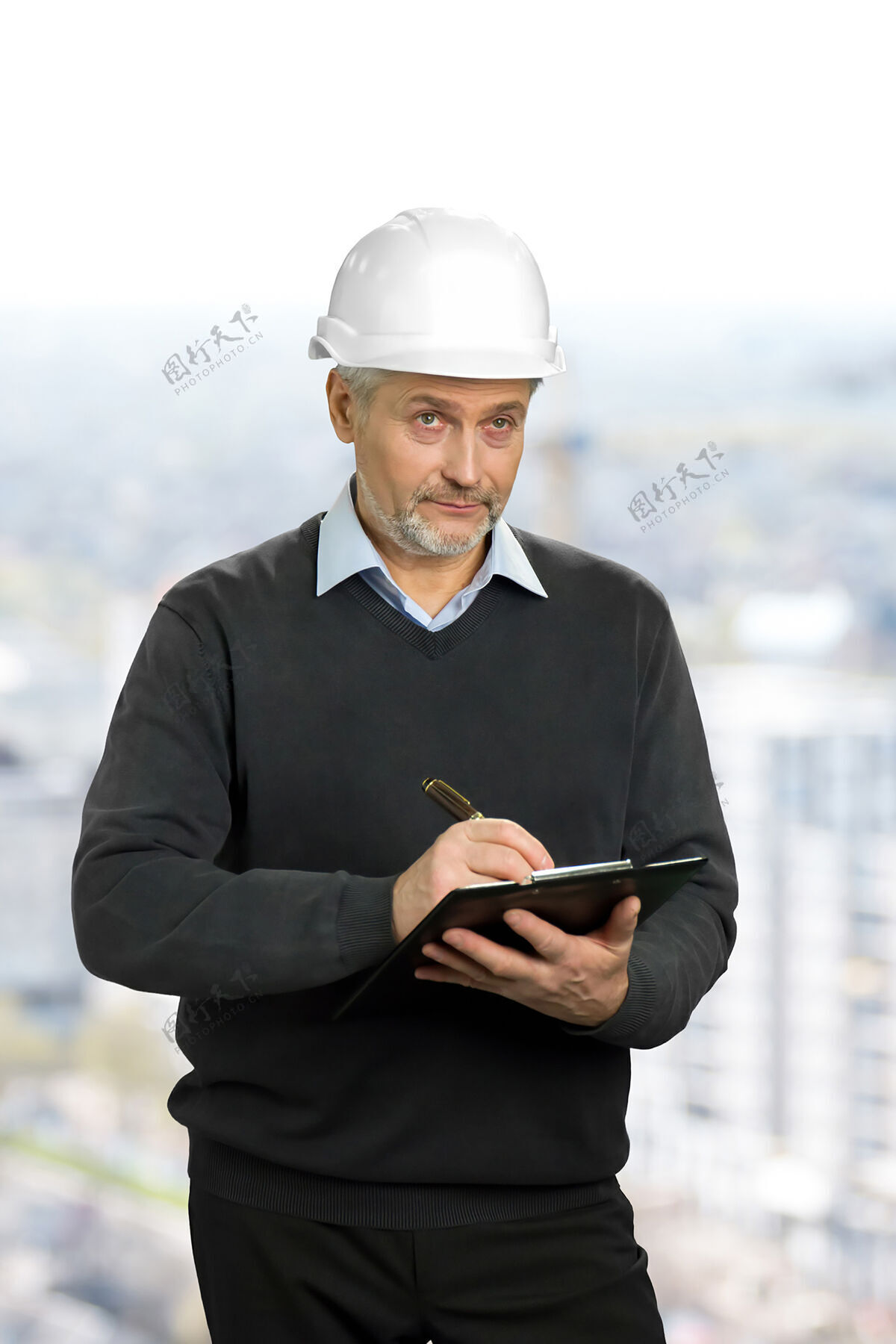 检查成熟的建筑师看着物体年长的工程师戴着安全帽拿着剪贴板检查物体控制保护文书工作