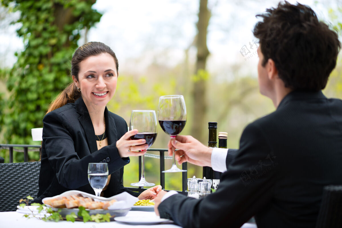 商务人士商务人士在一家高级餐厅的露台上享用商务午餐西装露台红酒