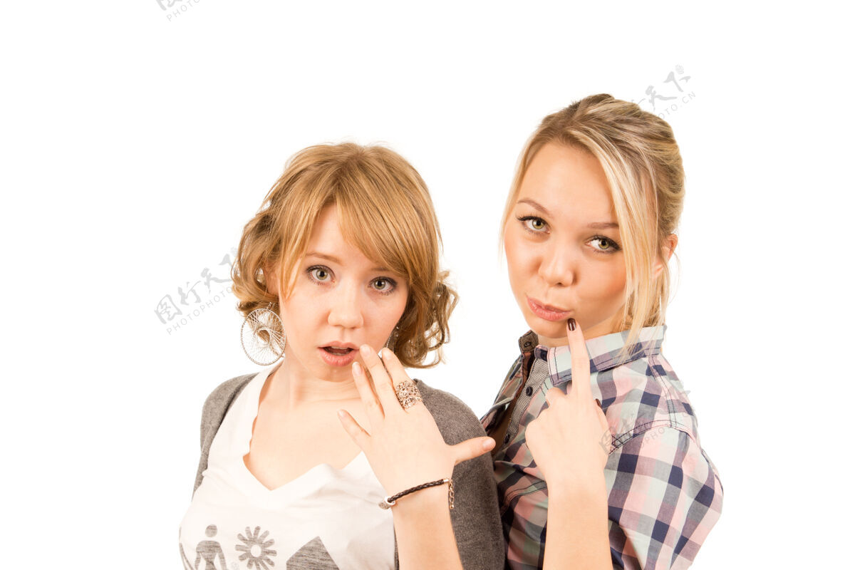 华丽两个年轻漂亮的金发女孩表达了有趣的怀疑和惊讶人青年姿态