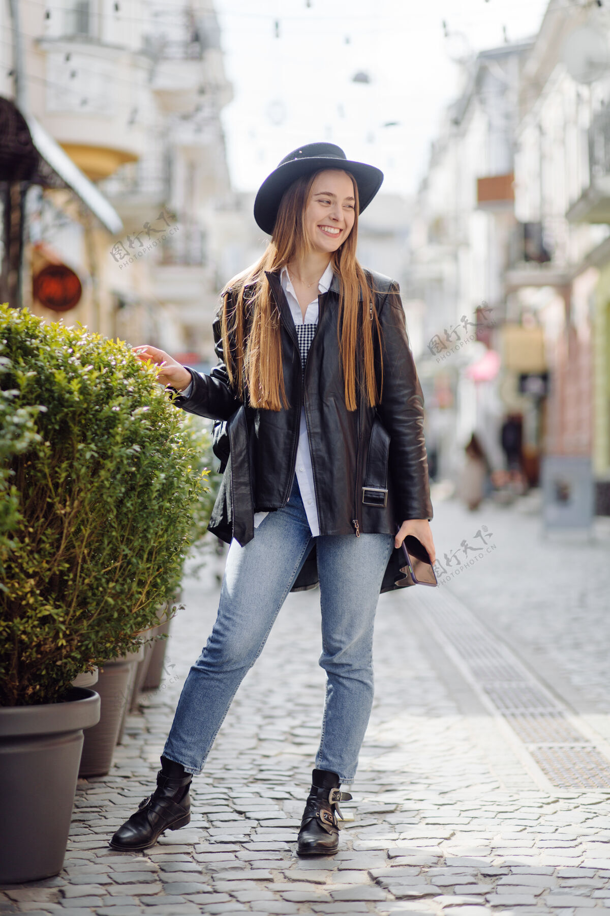 走道一个年轻漂亮的女孩微笑着摆姿势在城市里走来走去身体路径华丽