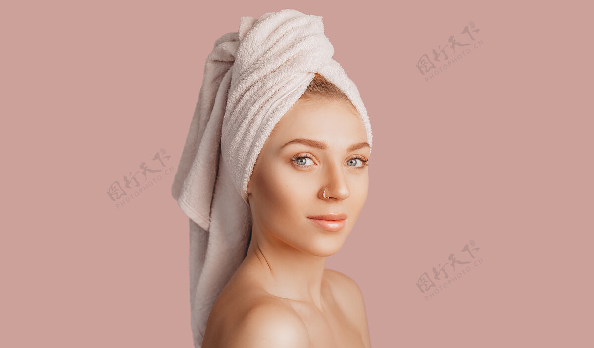 面部美丽性感的年轻女孩与清洁的皮肤上的粉红色空间与模型肩膀女性休息