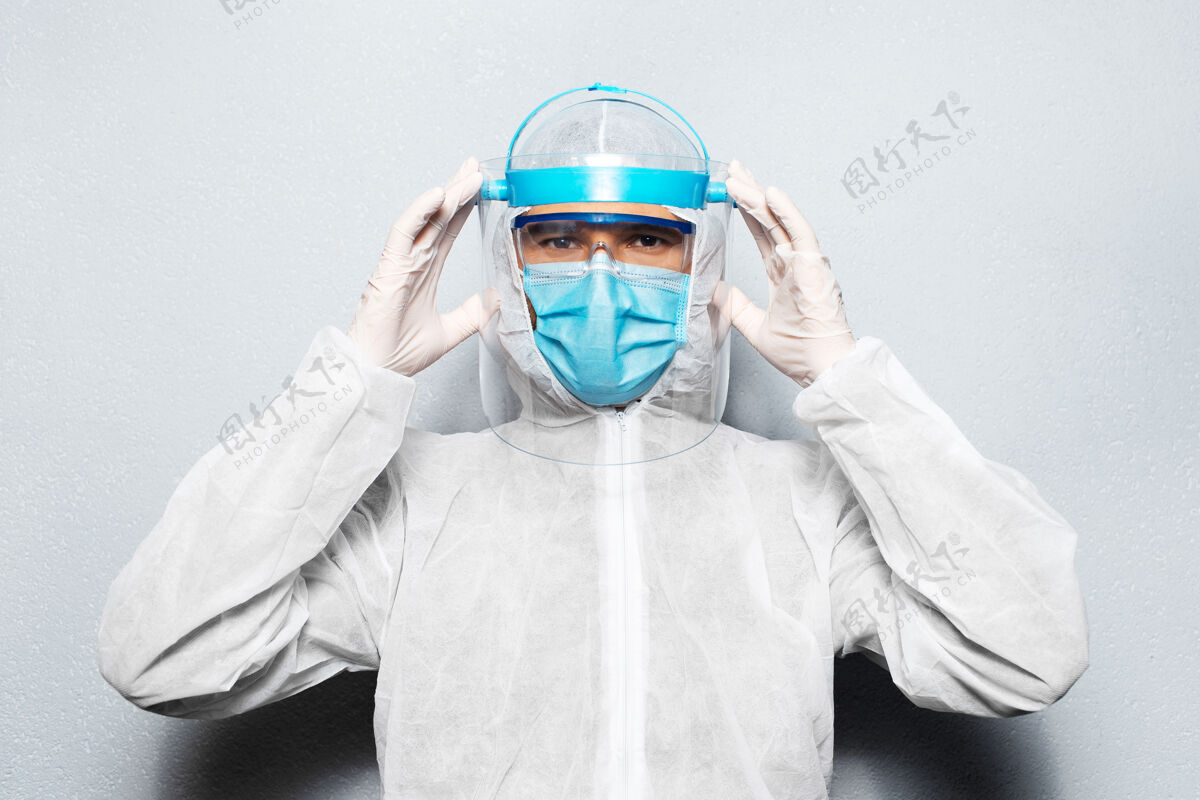 防护身穿防冠状病毒和covid-19防护服的年轻医生的肖像 纠正了安全帽人员护理医疗保健